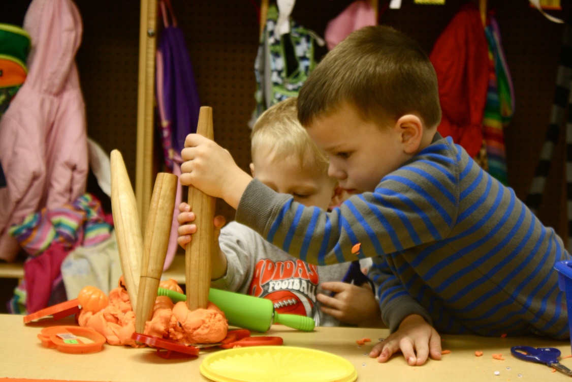 photo of children playing with play dough and rollers